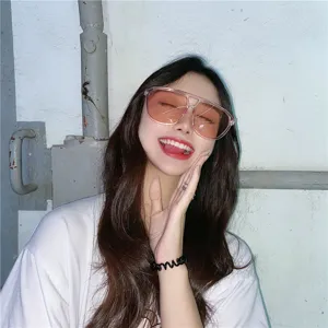 Detailaufnahme von großer transparenter Sonnenbrille mit pinken Gläsern, Retro Streetstyle.