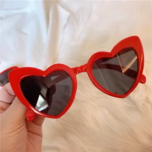 Nahaufnahme von roten Herz-Sonnenbrillen, trendige Mode-Eyewear mit schwarzen Gläsern.