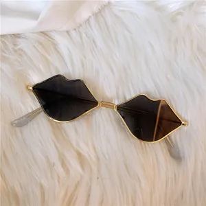 Schicke lippenförmige Sonnenbrille mit goldnem Metallrahmen und dunklen Gläsern für Damen.