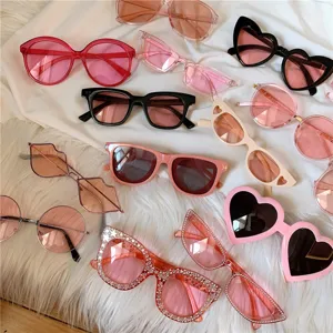 Nahaufnahme trendiger rosa und schwarzer Sonnenbrillen mit Herzen und funkelnden Sternen.