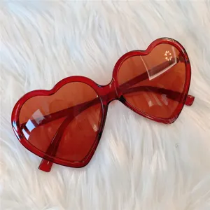 Rote herzförmige Sonnenbrille Detailaufnahme, modische Trend-Brille mit roten Gläsern.