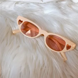 Detailansicht rosa Sonnenbrille im Cat-Eye-Stil mit niedlichen Herzen und Vintage-Design.