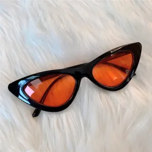 Nahaufnahme von Retro-Cat-Eye-Sonnenbrille mit schwarzem Gestell und roten Gläsern.