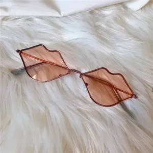 Lippenförmige, ausgefallene Sonnenbrille mit rosa Gläsern und filigranem Metallrahmen Detail.