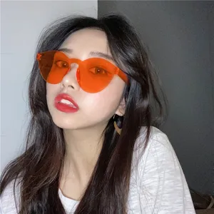 Detailopname van trendy frameloze jelly oranje zonnebril, stijlvolle retro feestbril op model.