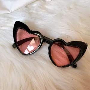 Herzförmige Sonnenbrille mit schwarzem Gestell und rosa Gläsern für süssen Retro Look.