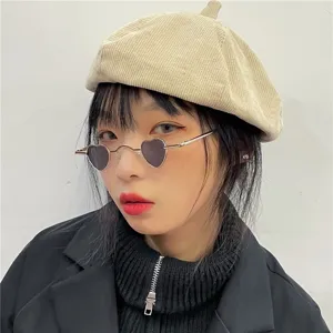 Nahaufnahme einer stilvollen Mini-Herz-Metallsonnenbrille kombiniert mit beiger Cord-Barette.