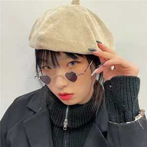 Detailaufnahme von trendigen herzförmigen Sonnenbrillen und Kordbaret, cooler Streetwear-Look.