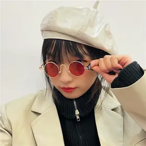 Close-up detail of retro round metal frame sunglasses with red lenses, vintage style aesthetic.