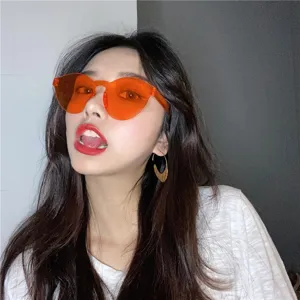 Close-up detail van levendige oranje gelei kleur rimless zonnebril, streetwear stijl.