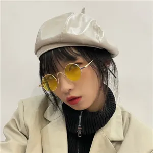 Retro metal round sunglasses detail view showing classic yellow tinted lenses and fine frame.