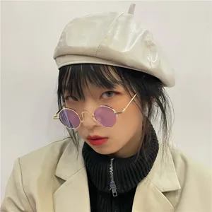 Vintage round metal frame sunglasses with purple lenses detail shot, stylish and classic.