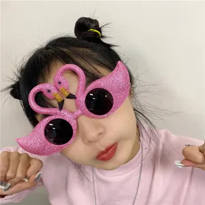 Funny pink flamingo party sunglasses with glitter finish, ideal for holiday photo props.