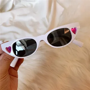 White Harajuku retro cat-eye sunglasses with pink heart cutouts, detailed close-up view.