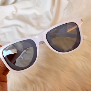 White frame retro sunglasses for women and men, stylish chunky sun glasses with dark lenses.