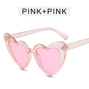 Rosa Glitzer Herz Sonnenbrille Detailaufnahme mit süßem Harajuku Stil Rahmen und getönten Gläsern.