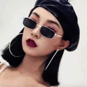 Detailaufnahme von kleinen, eckigen Metallsonnenbrillen im Vintage-Look am asiatischen Model.
