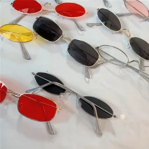 Nahaufnahme von Vintage-Sonnenbrillen mit schmalem Metallrahmen und verschiedenen bunten Gläsern.