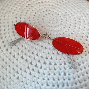 Nahaufnahme Detail von rötlichen ovalen Vintage Sonnenbrillen mit Metallgestell.
