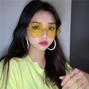 Detailed close-up of trendy yellow oversized rimless sunglasses worn by an Asian model.
