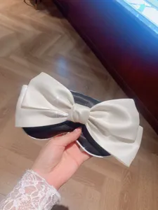Masque de sommeil élégant en satin noir et blanc avec un grand nœud pour de douces siestes.