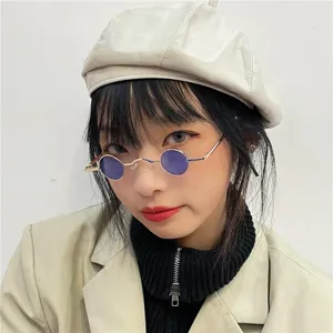 Nahaufnahme von retro runden Sonnenbrillen mit violetten Gläsern und Metallrahmen im Vintagestil.