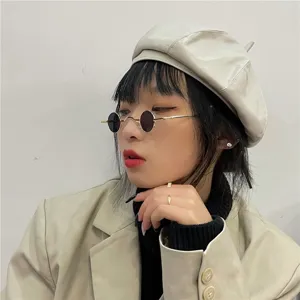 Nahaufnahme Detail der runden Retro-Metallsonnenbrille getragen vom Model, stylischer Look.