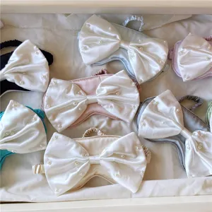 Detailansicht von Satin Schlafmasken mit großer Schleife und Perlen in verschiedenen Farben.