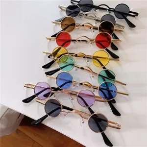 Nahaufnahmen von Retro-Mikro-Sonnenbrillen mit runden Metallrahmen und bunten Gläsern.