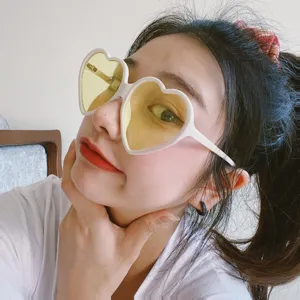 Retro süße herzförmige Sonnenbrille mit weißem Rahmen und gelben Gläsern für Damen.