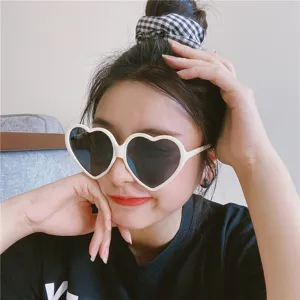 Süße herzförmige Sonnenbrille mit weißen Fassungen für süße Mädchen und Streetwear Looks.