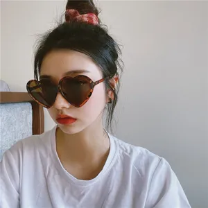 Detailaufnahme einer modischen herzförmigen Sonnenbrille mit stilvollem Leo-Muster.