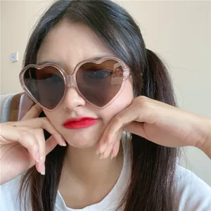 Nahaufnahme einer retro rosa herzförmigen Sonnenbrille mit braunen Gläsern für Damen.
