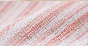 Nahaufnahme des weichen rosa-weißen gestreiften Stoffes für süße Hundeprinzessinnenkleidung.