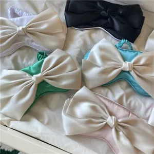 Vue détaillée de plusieurs masques de sommeil en satin avec de grands nœuds élégants.