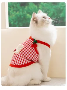 Detailopname van schattig rood-wit geruit huisdierenvest met kersenbandjes voor katten en honden.
