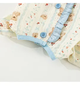 Close-up detail view of cute bear and cherry printed pet clothes with sweet blue ruffles.