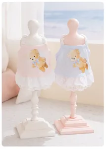 Detailopname van schattige huisdierenjurk met berenprint op mini-paspoppen, zachte zomerse stijl.