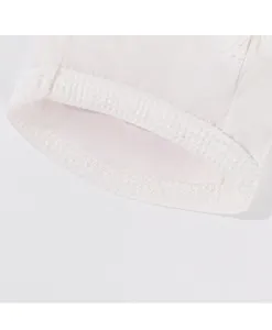 Primer plano del tejido blanco transpirable para mascotas, con costuras finas y textura.