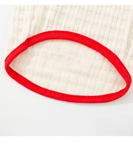 Dettaglio di abbigliamento per cani in tessuto strutturato traspirante con bordo rosso.