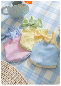 Detailed close-up of cute puppy summer vest with heart texture and plaid bow design.