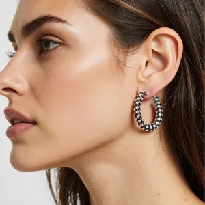 Boucles d'oreilles créoles strass noires épaisses, gros plan stylé, bijou de mode européen.