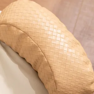Detailed close-up view of beige woven leather pet bed cushion showcasing fine craft and texture.