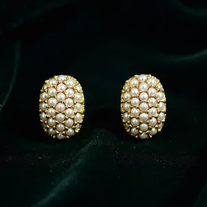 Vue rapprochée détaillée de boucles d'oreilles perles ovales vintage avec base dorée.