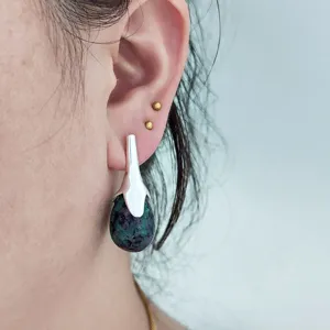 Détail en gros plan de boucles d'oreilles pendantes en pierre gemme en forme de goutte, style bohème.