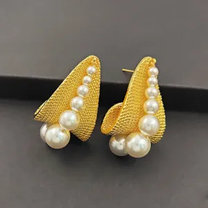 Vue détaillée des boucles d'oreilles puces perles filet doré vintage, bijoux au design de niche unique.