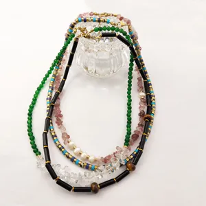 Vue détaillée de colliers de perles multiples avec aventurine verte, perles et tubes noirs.
