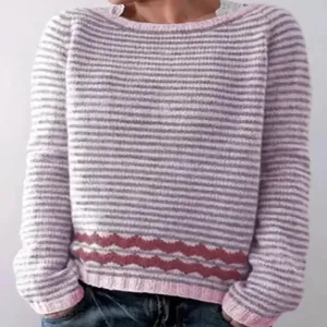 Nahaufnahme des Damen Strickpullovers, rosa-graue Streifen und Wellenmuster Detail.