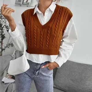 Detailed view of women cable knit V-neck sweater vest layered with white shirt top.