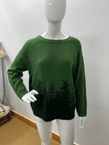 Detailansicht des grünen Pullovers mit einem stilvollen schwarzen Baummuster am Saum.